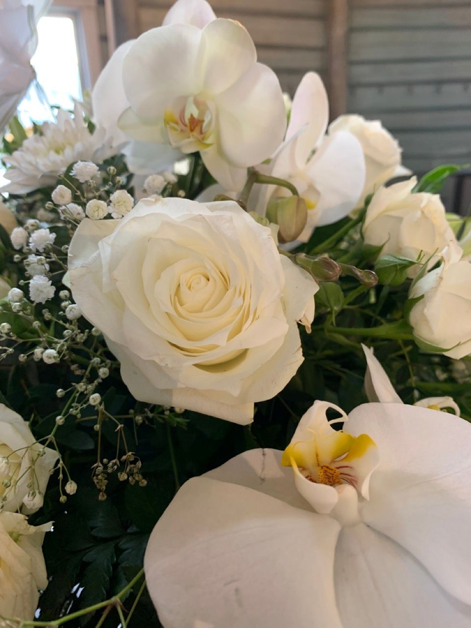 Hvite roser, orkidéer og brudeslør i bryllupsbukett