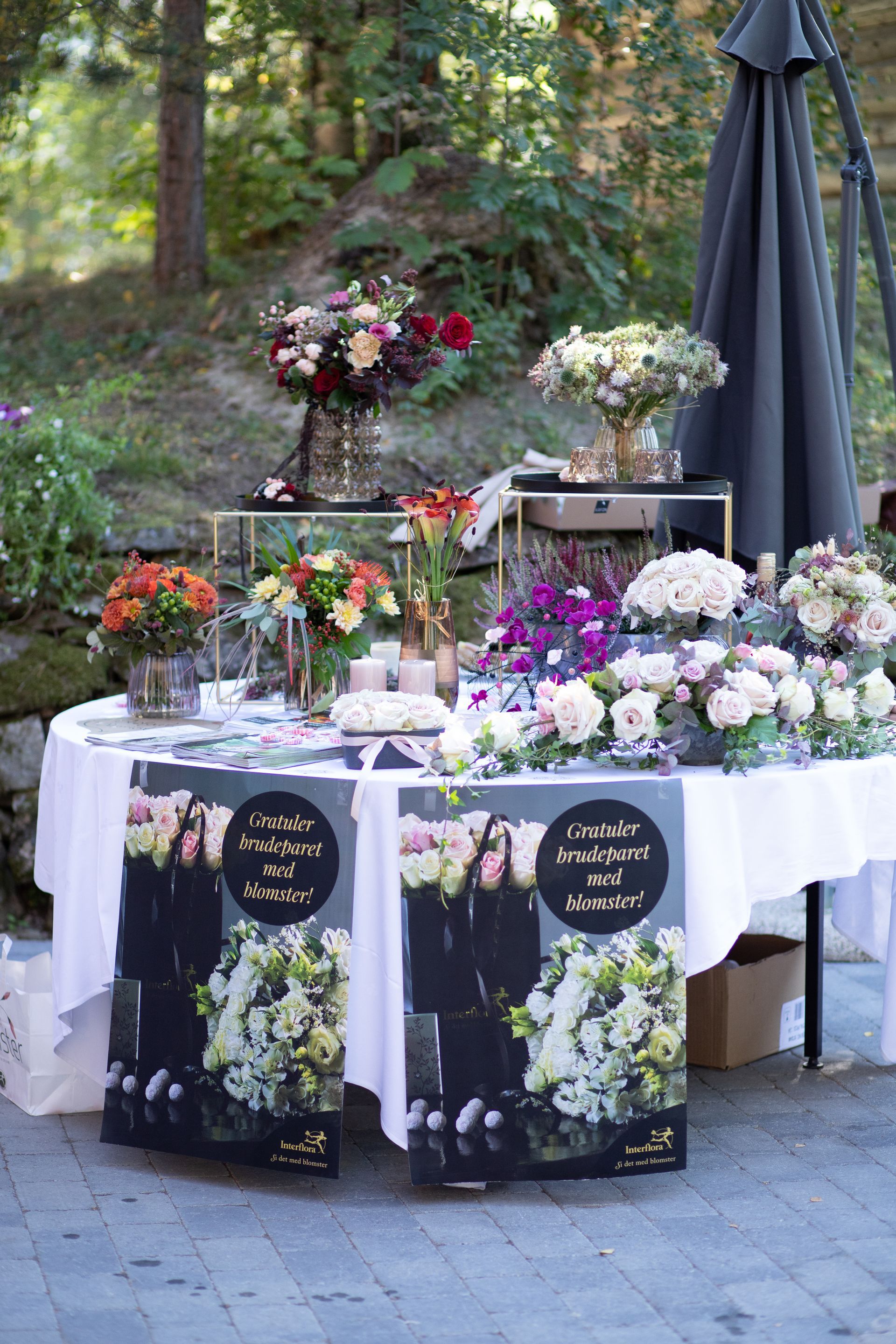 Bryllupsbord dekorert med rosa, røde og hvite buketter fra Storgata Blomster